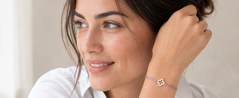 Frau trägt ein selbst gestaltetes Textilarmband mit Kleeblatt-Symbol aus 925 Silber